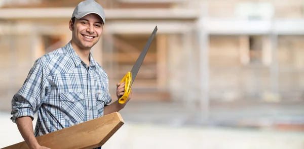 Portrait Smiling Carpenter Holding Wood Plank Saw Construction Site — Stock Photo, Image