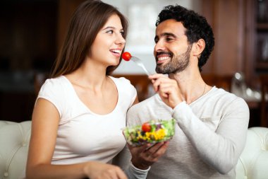 oturma odasında bir salata yemek Çift.