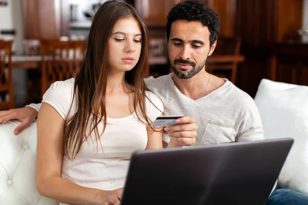 ラップトップとクレジットカードを使用してオンラインで商品を購入するカップル — ストック写真