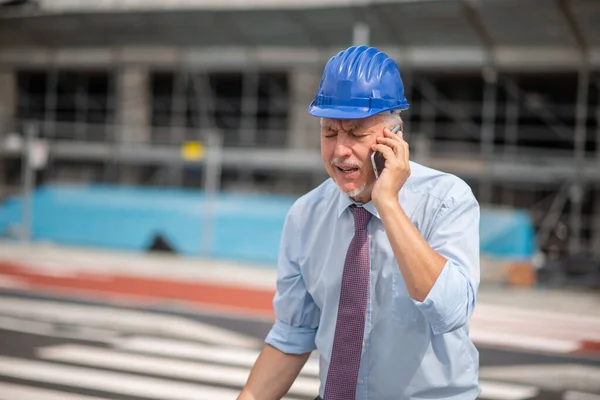 Злой Архитектор Менеджер Разговаривает Мобильному Телефону Перед Строительной Площадкой — стоковое фото