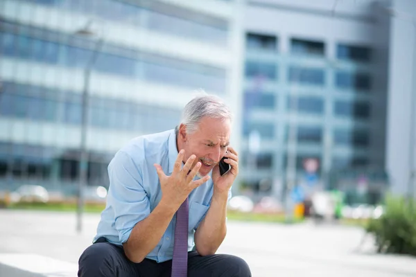 Starszy Biznesmen Korzystający Telefonu Komórkowego Świeżym Powietrzu Siedząc Ławce Przed — Zdjęcie stockowe