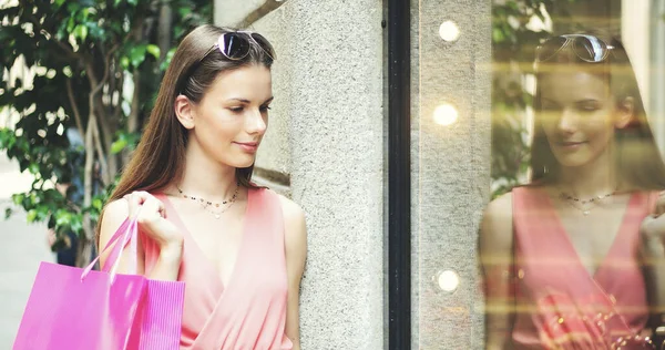 Güzel bir genç kadın modern bir şehirde açık hava dükkanını kontrol ediyor. 