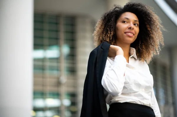 年轻自信的非洲裔美国女经理穿着夹克站在现代都市的室外 — 图库照片