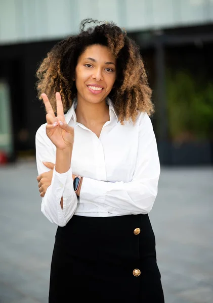 自信的年轻非洲裔美国女经理在户外微笑着 用手指做胜利的标志 — 图库照片