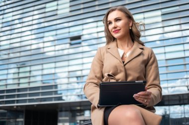 Gülümseyen iş kadını dijital tablet kullanıyor.