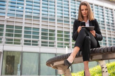 İş kadını tabletini kullanırken telefonda konuşuyor.