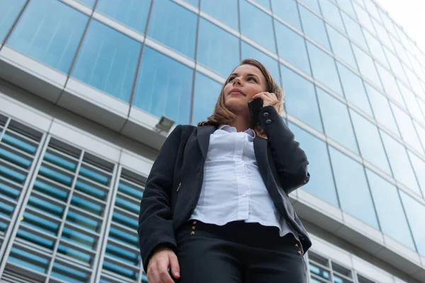 Genç iş kadını cep telefonuyla konuşuyor.
