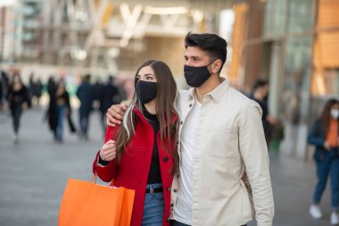 Covid ve Coronavirus alışverişi, alışveriş çantası taşıyan genç bir çift.