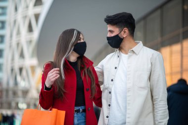 Covid ve Coronavirus alışverişi, alışveriş torbaları taşıyan genç bir çift.