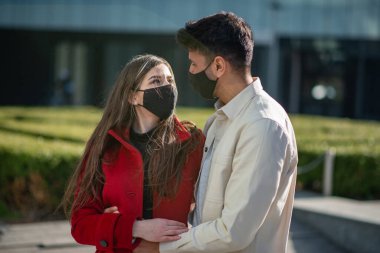 Coronavirüs salgını sırasında şehirde yürüyen ve eğlenen bir çift.