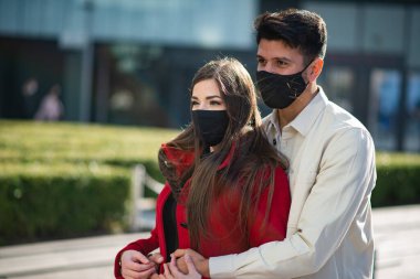 Coronavirüs salgını sırasında şehirde yürüyen ve eğlenen bir çift.