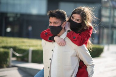 Coronavirüs salgını sırasında şehirde yürüyen ve eğlenen bir çift.