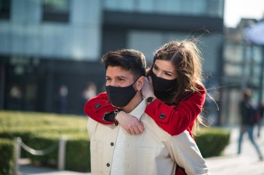 Coronavirüs salgını sırasında şehirde yürüyen ve eğlenen bir çift.