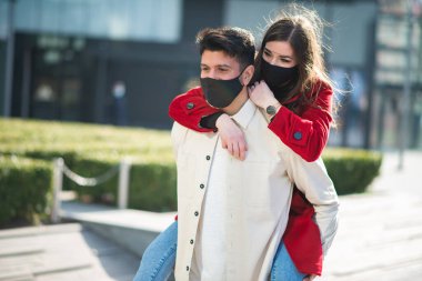 Coronavirüs salgını sırasında şehirde yürüyen ve eğlenen bir çift.