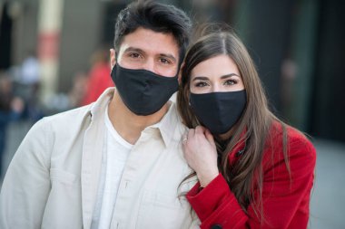 Maske takan genç bir çiftin portresi, covid ve coronavirus konsepti