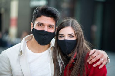 Maske takan genç bir çiftin portresi, covid ve coronavirus konsepti