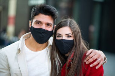 Maske takan genç bir çiftin portresi, covid ve coronavirus konsepti