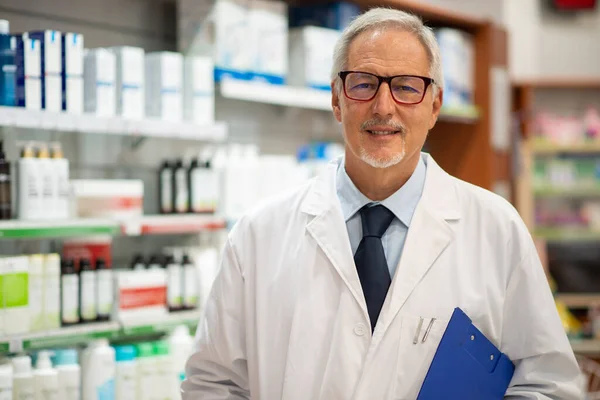 Portrait of an happy pharmacist in his pharmacy