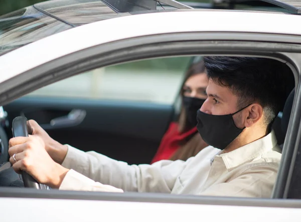 仮面のカップルは車の中で旅しますCovid Coronavirusの概念 — ストック写真