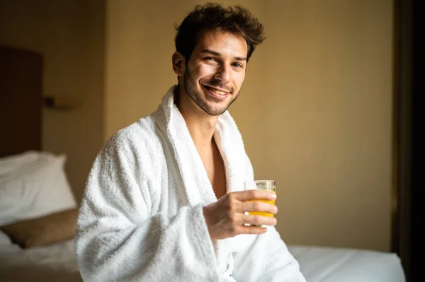 Portret Van Een Jongeman Een Witte Badjas Die Sinaasappelsap Drinkt — Stockfoto