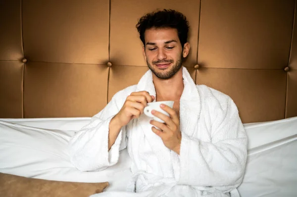 年轻英俊男子穿着浴衣喝早茶 — 图库照片