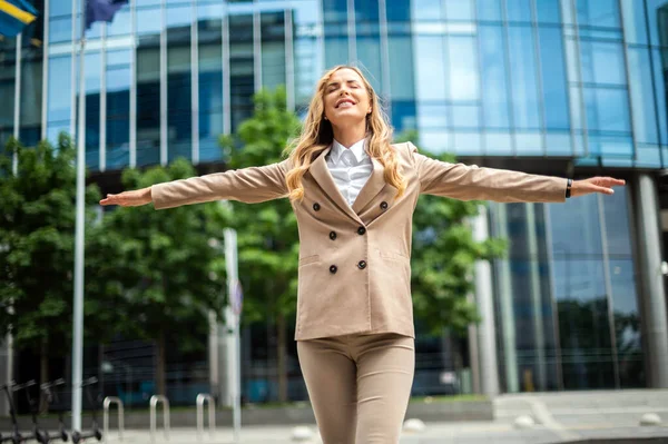 Happy female manager with open arms in sign of freedom and success