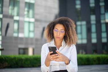 İş ortamında cep telefonunu kullanan bir iş kadınının portresi