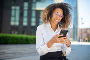 İş ortamında cep telefonunu kullanan Afrikalı bir Amerikalı iş kadınının portresi.