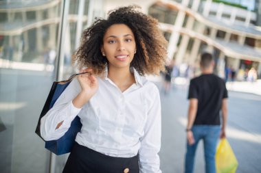 Alışveriş torbaları tutan genç bir kadın.