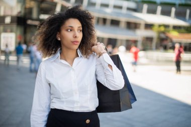 Alışveriş torbaları tutan genç bir kadın.