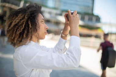 Afro-Amerikalı kadın dijital kamera kullanıyor.