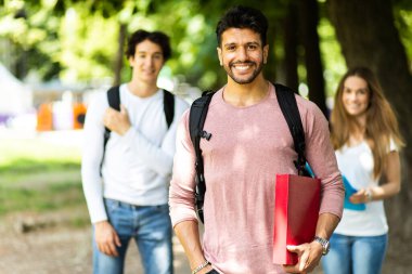 Dışarıdaki mutlu öğrenciler güvenle gülümsüyor.