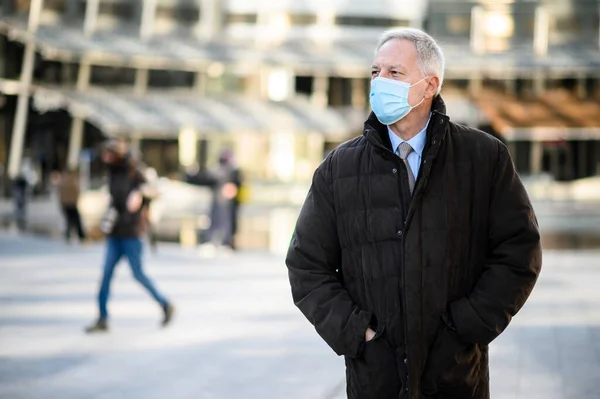 コロナウイルスのパンデミックに対する保護マスクを身に着けているシニア男の屋外 — ストック写真