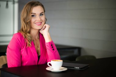 Kafede kahve içen güzel bir kadın.