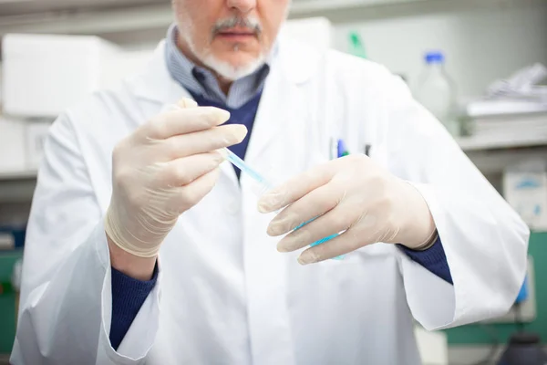 Laboratuarda Mavi Sıvı Şişesi Tutan Bir Erkek Araştırmacının Yakın Çekim — Stok fotoğraf