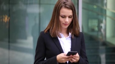 Açık bir smartphone kullanarak gülümseyen iş kadını