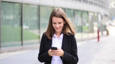 Açık bir smartphone kullanarak gülümseyen iş kadını