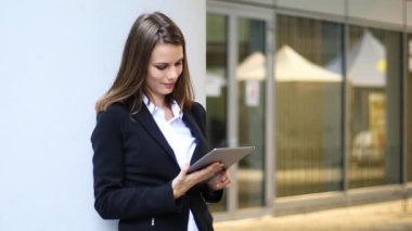 Gülümseyen iş kadını dijital tablet kullanıyor.