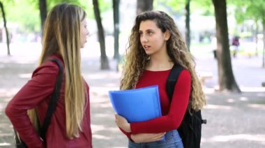 Üniversite bahçesinde konuşan iki kız okul arkadaşı.