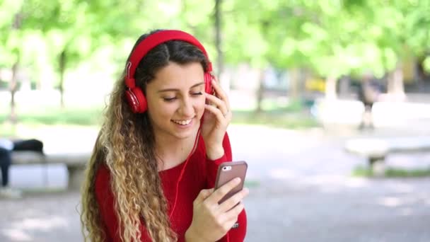 Mujer Escuchando Música Sentada Banco Parque — Vídeo de stock