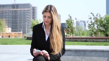 Açık bir smartphone kullanarak gülümseyen iş kadını