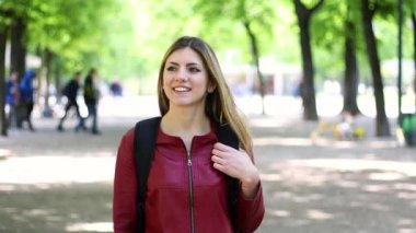 Gülümseyen öğrenci dışarıda yürüyor. 