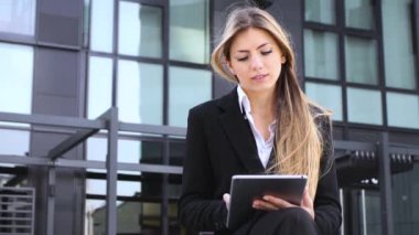 Gülümseyen iş kadını dijital tablet kullanıyor.