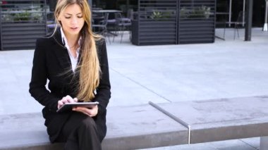 Gülümseyen iş kadını dijital tablet kullanıyor.