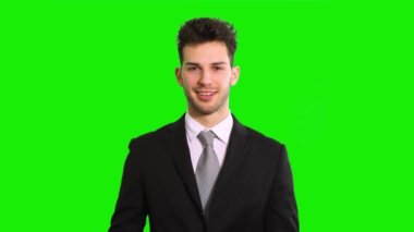 Gülümseyen iş adamı yeşil ekran krom anahtar arka planında izole edilmiş kartvizitini gösteriyor.