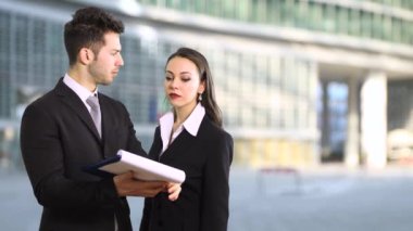 İş adamı ve kadın bir belgeyi okurken tartışıyorlar