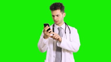 Akıllı telefon ekranına bakan doktor yeşil ekran krom anahtar arka planında izole