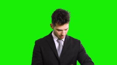 İş adamı yeşil arka planda saati izliyor 