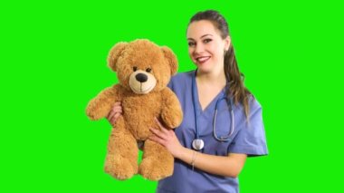 Oyuncak ayı tutan güzel hemşire, çocuk doktoru konsepti.