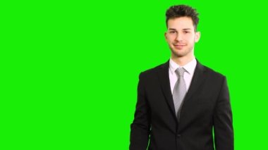 İşaret parmağıyla solu gösteren genç bir yöneticinin portresi, yeşil ekran krom anahtarı üzerinde izole edilmiş.